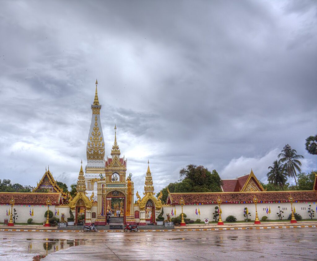 Weiß-goldener Stupa des Wat Phra That Phanom nach einem Regenschauer